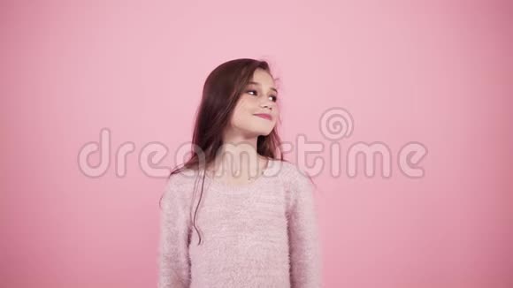 可爱的长发女孩被隔离在粉红色的背景上看着两边然后显示拇指向上的手势模板视频的预览图