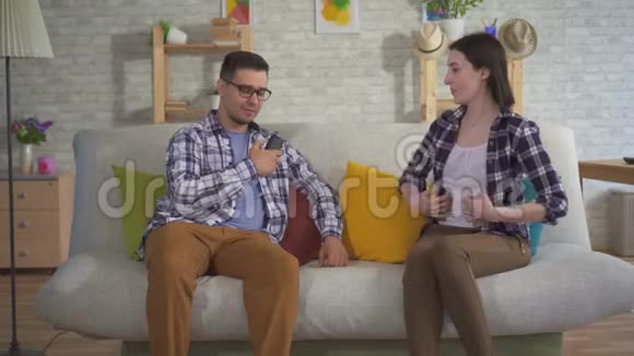 一个男人和一个坐在沙发上的年轻女人交流用言语辅助视频的预览图