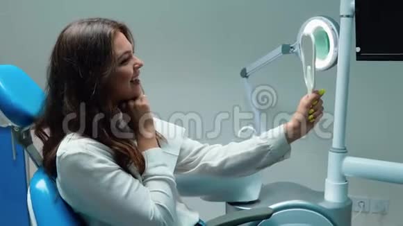 布鲁内特女士的病人看起来很高兴看着镜子里的人坐在镜子里笑着视频的预览图