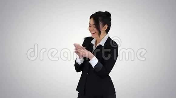 快乐的年轻女子在正式的舞蹈和使用手机梯度背景视频的预览图