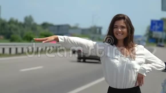 美丽的年轻性感的黑发女人在她的车出了问题后试图停止在路上路过汽车视频的预览图