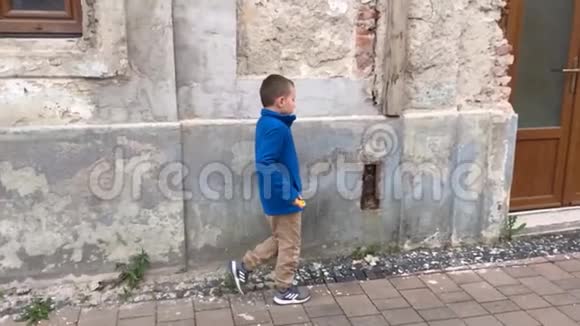 年轻悲伤的男孩在城里慢动作地走在街上视频的预览图