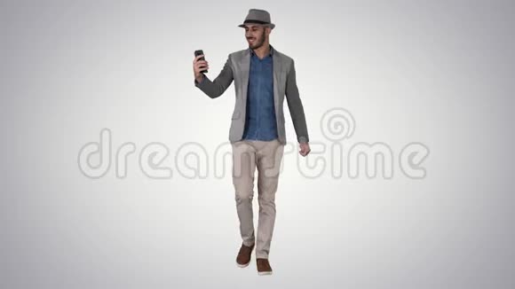 有魅力的男人穿着休闲服装帽子时髦的风格记录vlog或在渐变背景下打视频电话视频的预览图