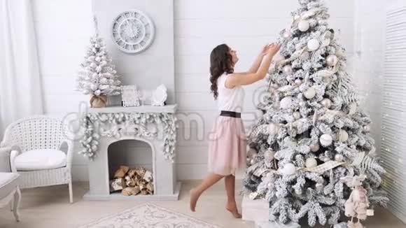 漂亮的黑发装饰圣诞树的背景是一个美丽的内部圣诞传统快乐视频的预览图