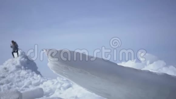 披着温暖外衣的长发站在冰川顶部的女人的剪影举起双手胜利了视频的预览图