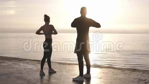 健身运动训练和生活方式的概念微笑的夫妇在户外伸展在海边的早晨视频的预览图