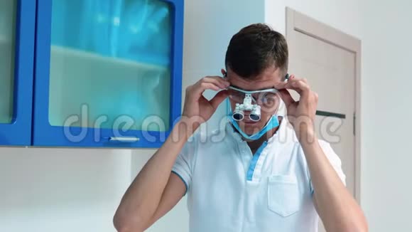 年轻的医生戴着手术刀在诊所里调整他的牙科眼镜视频的预览图