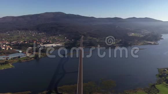 从无人驾驶飞机上通过日落光线从无人驾驶飞机上拍摄的桥过河的俯视图视频的预览图