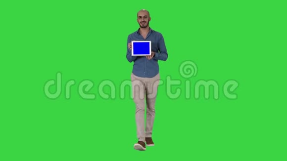 阿拉伯男人走着展示平板电脑在绿色屏幕上展示一些东西Chroma键视频的预览图