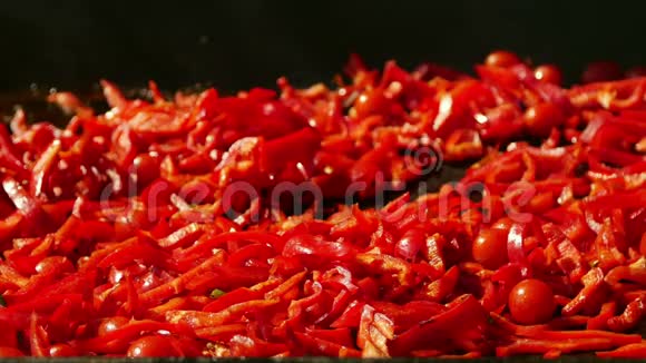 厨师在平底锅上烤辣椒和樱桃番茄视频的预览图