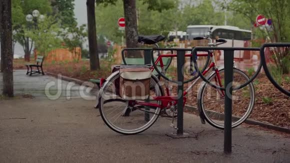 自行车停放在自行车上的红色自行车在雨中被淋湿视频的预览图