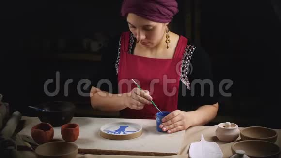 女人波特用自己的手画一个盘子体力劳动民间艺术视频的预览图