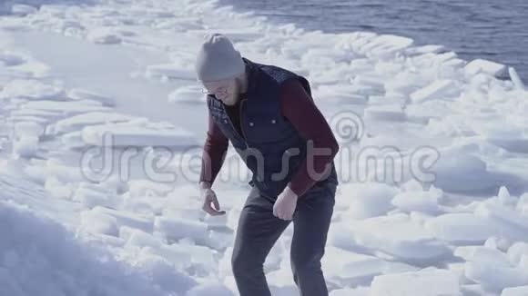 年轻英俊的地质学家在寒冷的冰雪冰川中搜寻了一些东西慢动作视频的预览图