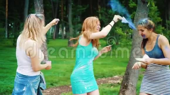 三位女性朋友在公园的霍利色节上撒了五颜六色的粉末视频的预览图