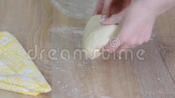 将面团包在保鲜膜中制作牛角面包视频的预览图