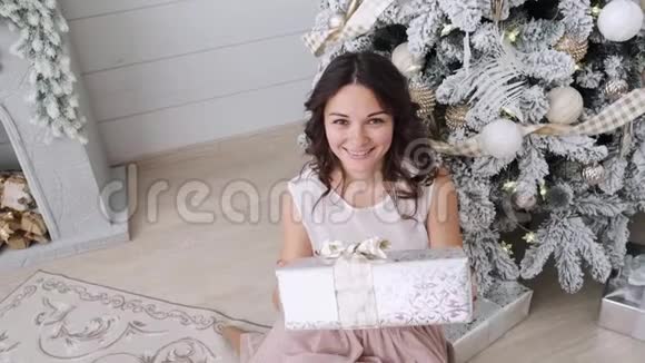 美丽的室内背景上有漂亮的深色头发和圣诞礼物圣诞屋内部视频的预览图
