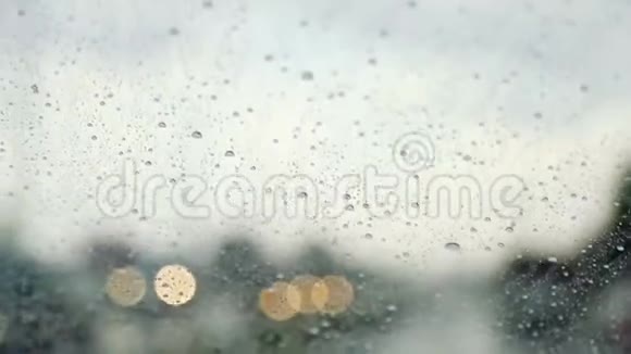 雨滴滴下移动汽车的挡风玻璃慢动作视频的预览图