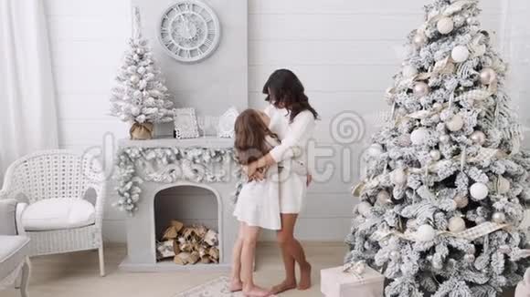 妈妈和女儿的背景是一个美丽的圣诞节内饰壁炉旁边的一家人妈妈和女儿视频的预览图