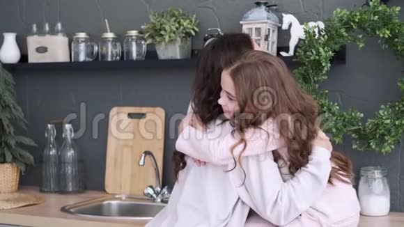 厨房里的幸福家庭妈妈和女儿穿着睡衣玩和跳舞妈妈在厨房拥抱女儿视频的预览图