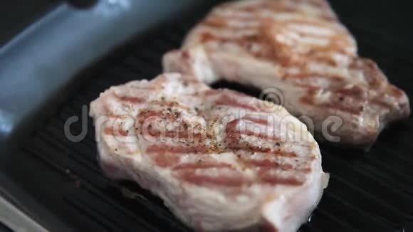 厨师在专业厨房的烤锅上煮肉在烤架上观看特写煎牛排现代美味视频的预览图