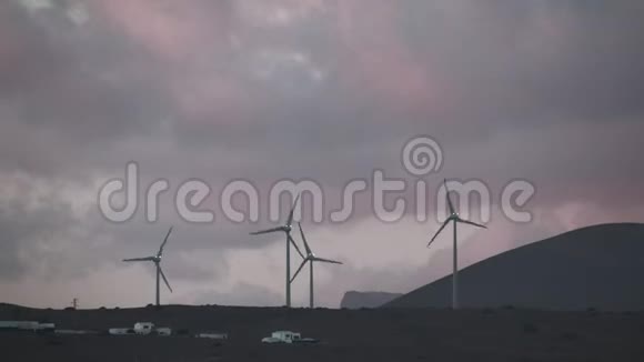 群山中的风车在五彩缤纷的夜空中旋转视频的预览图