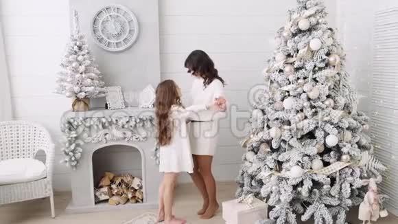 妈妈和女儿的背景是一个美丽的圣诞节内饰壁炉旁边的一家人妈妈和女儿视频的预览图