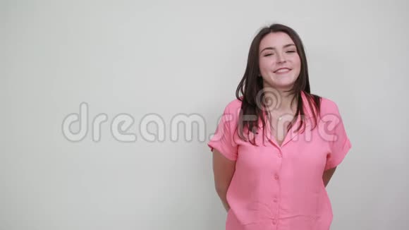 年轻的白种人穿着粉红色的衬衫表现出良好的姿态微笑视频的预览图