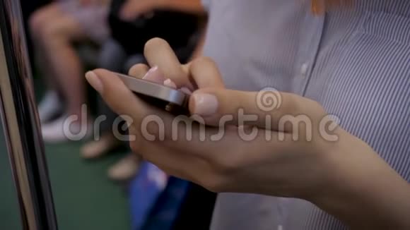 地铁汽车中使用智能手机的女性双手特写视频的预览图