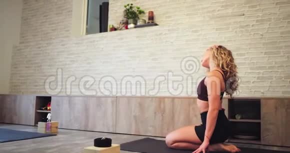 女士穿着运动服在运动垫上练习伸展身体练习她感到放松和放松视频的预览图