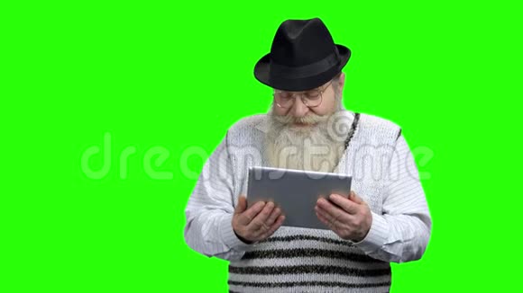 戴帽子的老人拿着电脑平板电脑视频的预览图