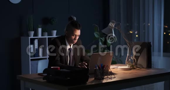 年轻的男性高管深夜在笔记本电脑上工作视频的预览图