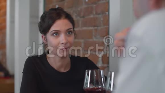 带着一杯酒的女人和男人一起吃饭视频的预览图