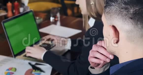 体贴的男人看到女人是如何在明亮的现代办公室工作的有关女性的笔记本电脑工作商务视频的预览图