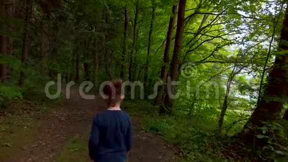 一个小女孩独自走在一条小径上在黑暗诡异的森林里视频的预览图