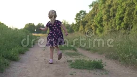 日落时分美丽的小女孩跑过田野视频的预览图