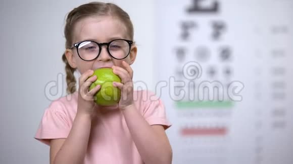 可爱的眼镜女孩吃苹果眼睛天然维生素医疗保健视频的预览图