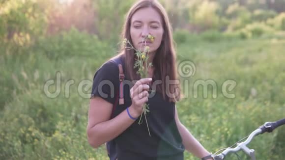 一个女人嗅着黄色的野花视频的预览图