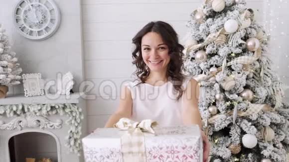 美丽的室内背景上有漂亮的深色头发和圣诞礼物圣诞屋内部视频的预览图