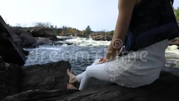 女人在流动的河流附近放松视频的预览图