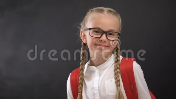 戴着眼镜对着镜头眨眼睛爱上学爱受教育的顽皮女学生视频的预览图