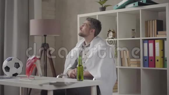 一个英俊的积极男人脱下希特长袍准备看足球和喝啤酒的肖像医生视频的预览图