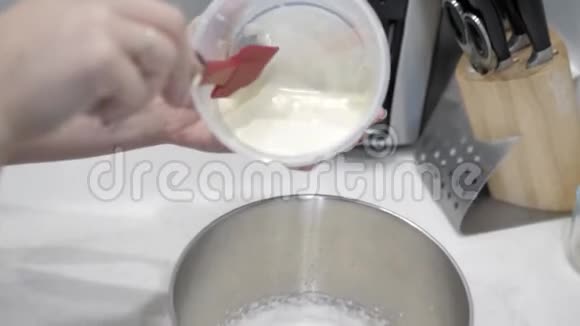 女性手将牛奶液体倒入金属杯中的白色底座特写视频的预览图