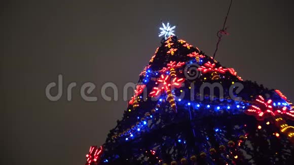 从底部观看美丽的圣诞树与节日装饰和花环的多色灯光对视频的预览图