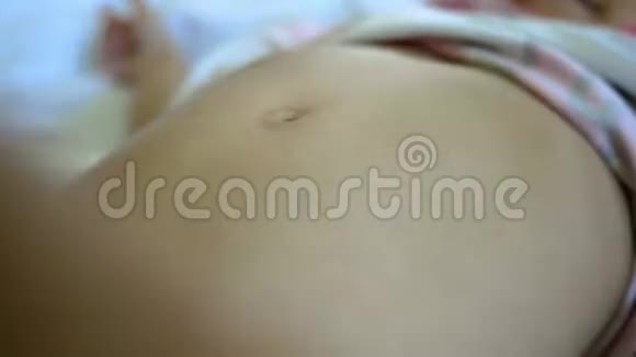 可爱的亚洲小女孩在床上涂滑石粉后她的母亲洗澡护肤理念视频的预览图