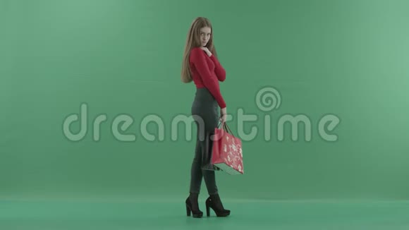 穿着休闲服的漂亮女人拿着购物袋在手机上说话她站在右边视频的预览图