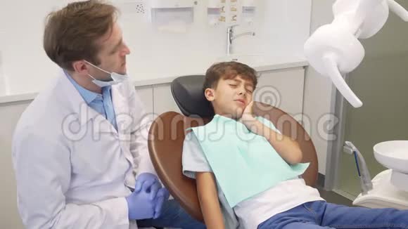 牙齿检查时小男孩得了头痛坐在牙椅上视频的预览图