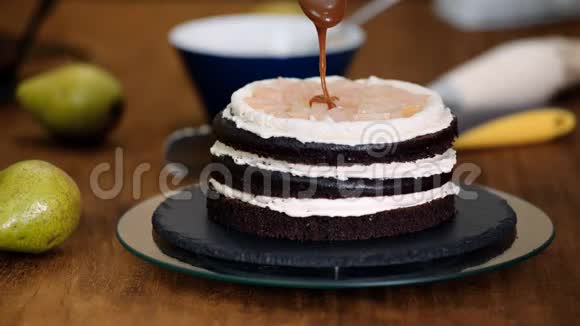 糕点厨师在巧克力海绵蛋糕上浇焦糖在面包店做蛋糕视频的预览图