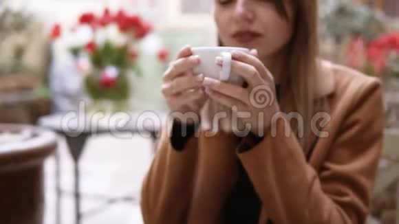 一位美丽的女性在享受中抬头在咖啡馆喝着美味的咖啡年轻貌美的女人视频的预览图