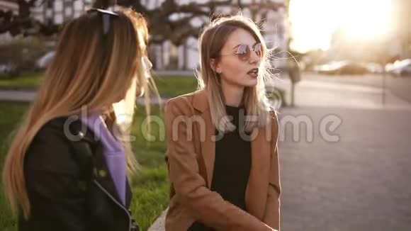 两个女孩坐在街上的慢镜头讨论女孩的事情修指甲指甲油等视频的预览图