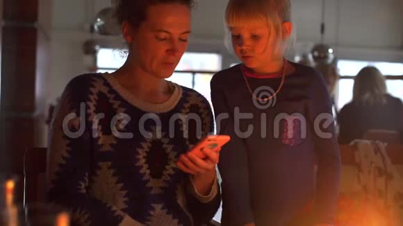 妈妈和女儿正在看智能手机的屏幕视频的预览图